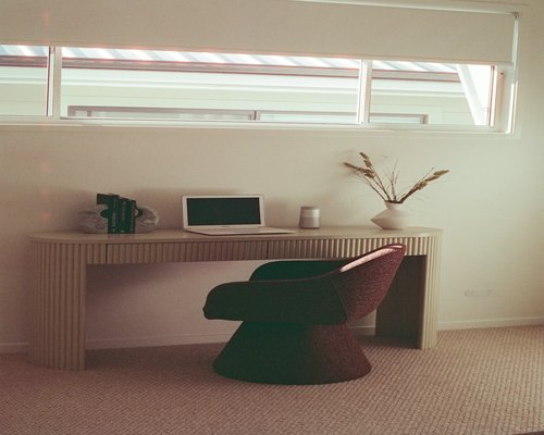A well-arranged modern home office desk with natural light from an adjacent window